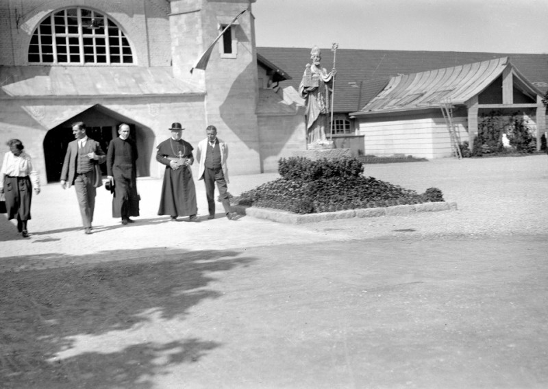 Historisches Foto: Gruppe vor Kirche mit Bischofsstatue. Geistliche, Gebäude, Schwarzweiß.