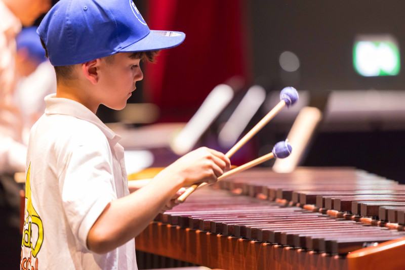 Junge spielt Xylophon. Musikinstrument mit Schlägeln, Konzert, Musiker.
