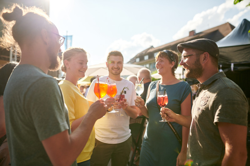 Gruppe feiert mit Cocktails im Freien. Aperol Spritz, Sommer, Freunde.