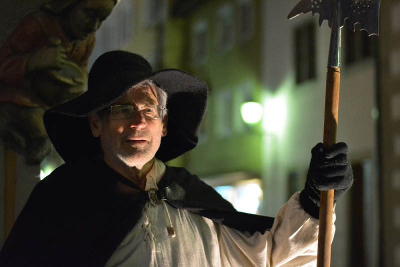 Mann in historischer Kleidung mit Hellebarde. Mittelalterlicher Nachtwächter auf Patrouille in der Altstadt.