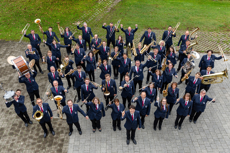 Großes Blasorchester in Uniform mit Musikinstrumenten für Konzert oder Festumzug. Bläserensemble mit Trompeten, Posaunen, Klarinetten, Saxophonen.